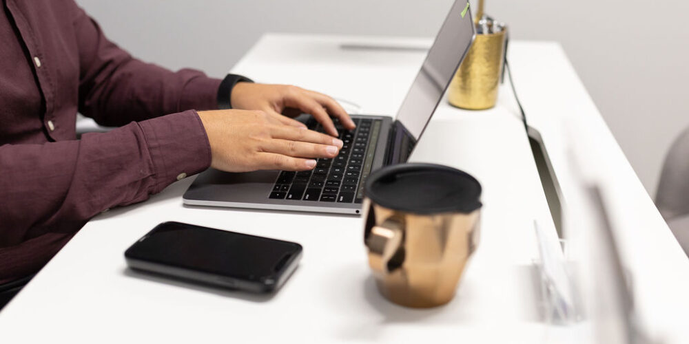 man sitting with a laptop with poor ergonomics displaying the need for occupational therapy treatment